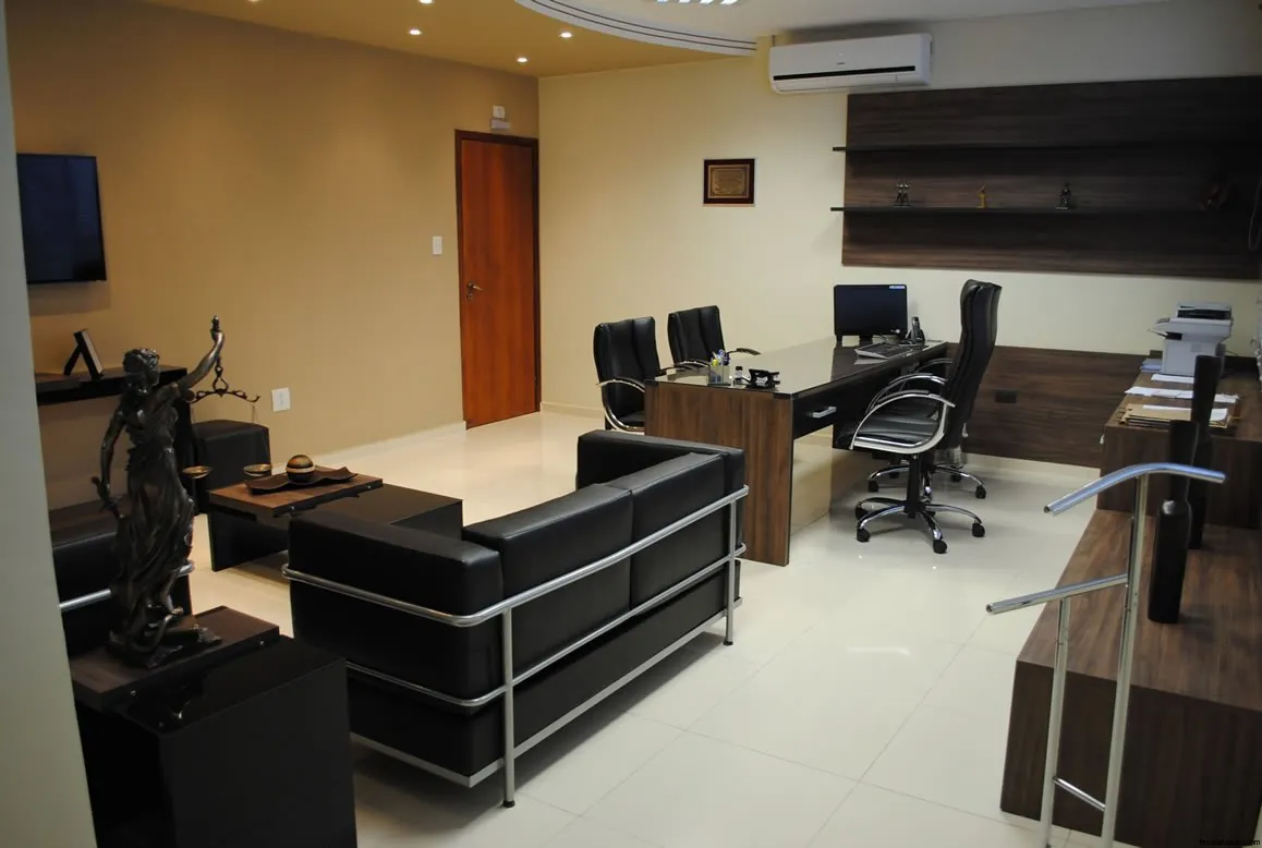 Sala de atendimento com sofá e estátua da Justiça